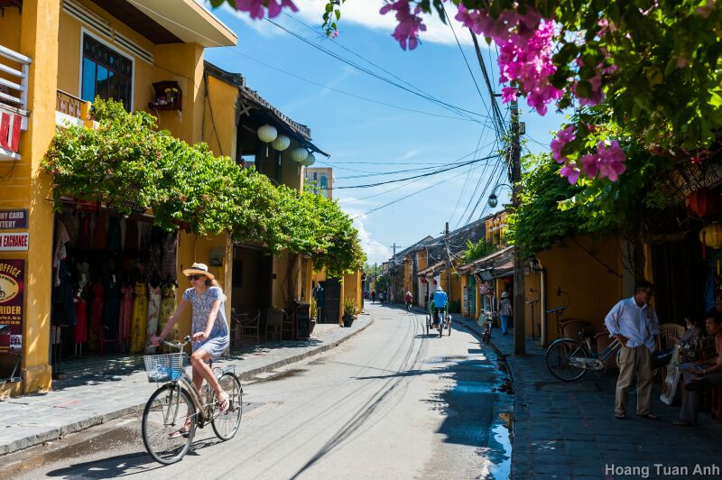 Tourists pedal along old houses in Hoi An. Photo: Hoang Tuan Anh